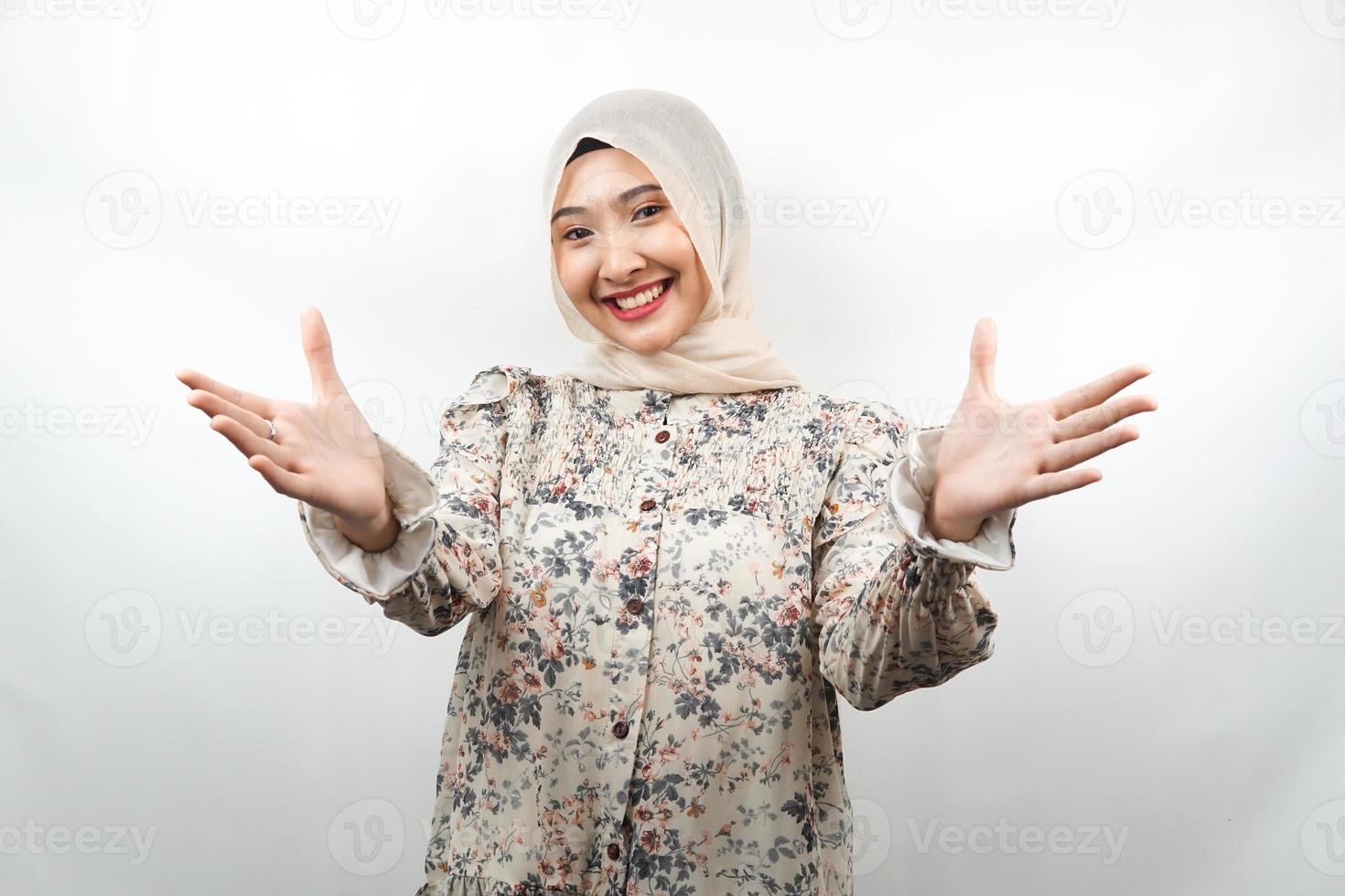 bela jovem asiática muçulmana sorrindo alegremente, com os braços abertos para a câmera, sinal de boas-vindas, sinal de mão querendo abraçar, isolado no fundo branco foto