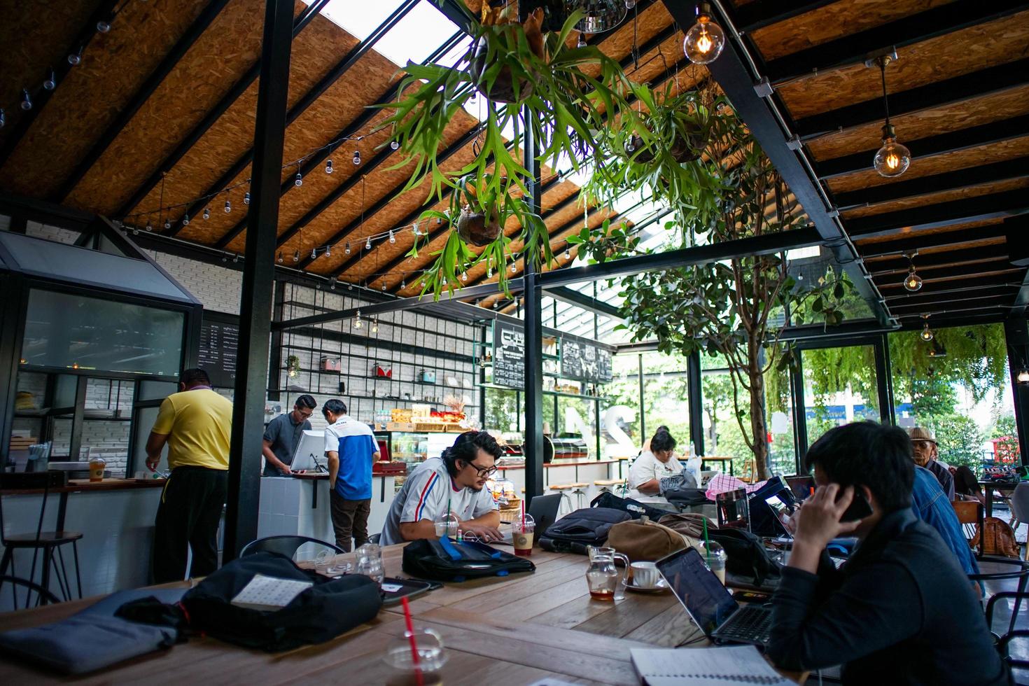 Banguecoque, Tailândia, 21 de março de 2018 - lotado de pessoas sentadas e trabalhando no café. estilo de vida das pessoas que trabalham fora do escritório. co conceito de espaço de trabalho foto