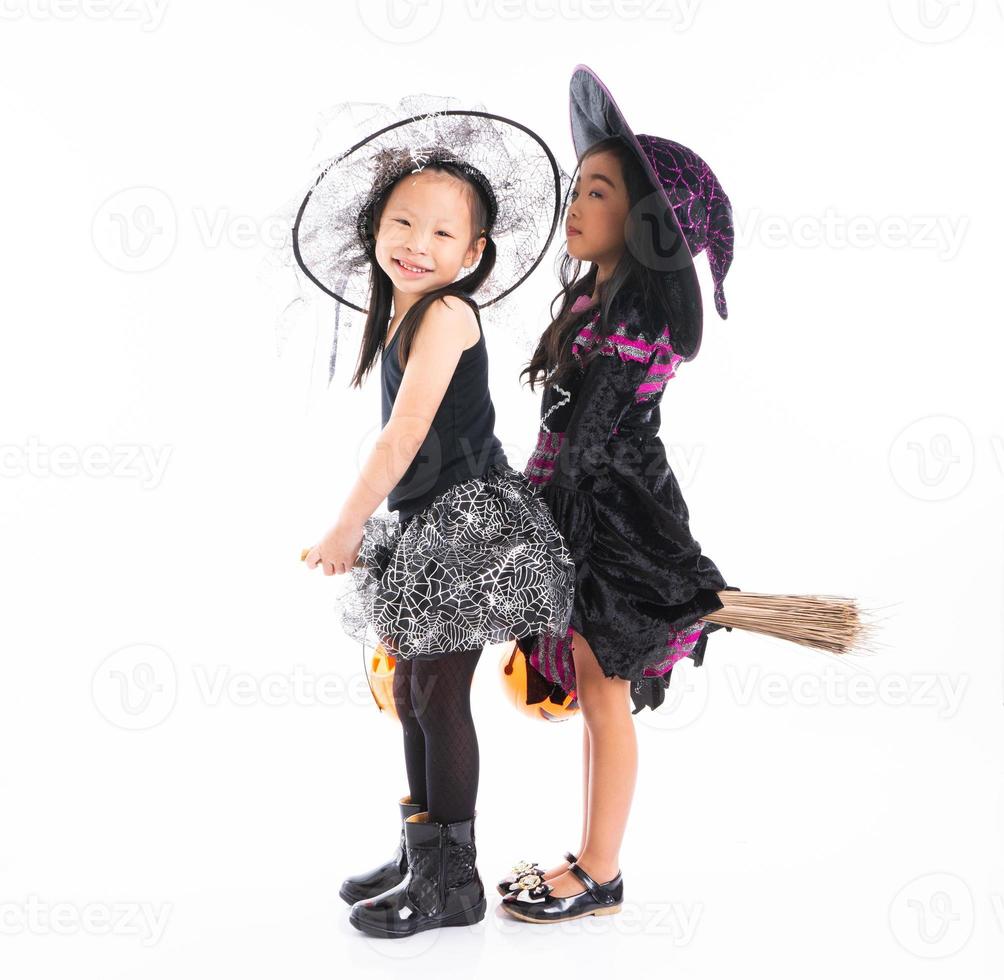retrato de meninas asiáticas com fantasia de halloween, andando na vassoura juntos e holind a abóbora com fundo isolado foto