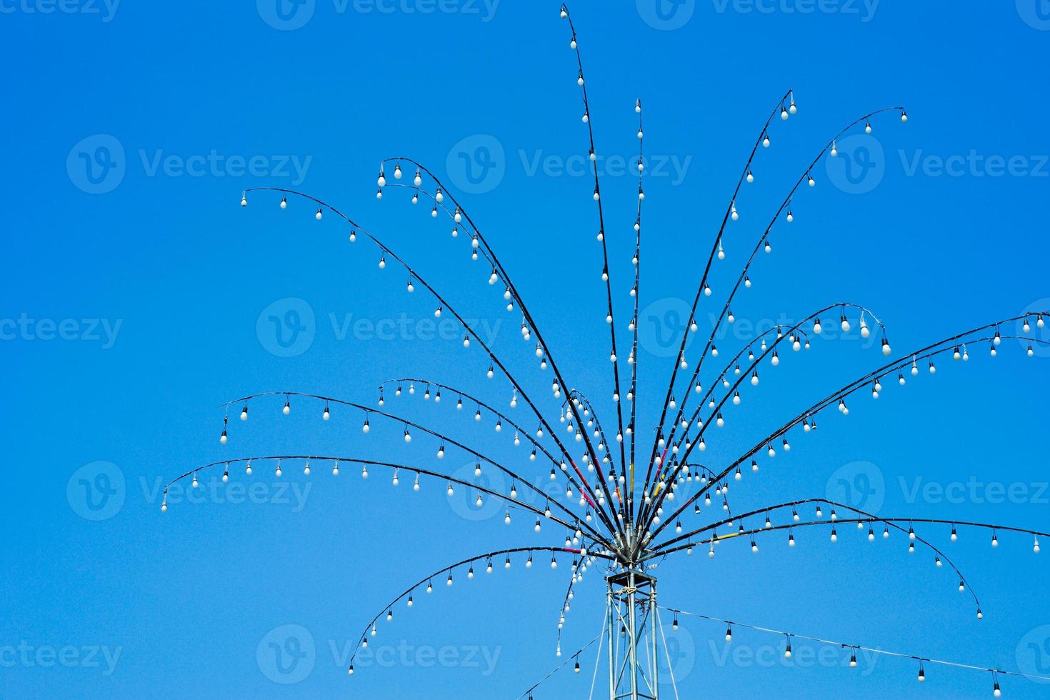 muitas lâmpadas decoradas nos galhos de aço em forma de flor para o festival local na Tailândia, isolado no fundo do céu azul foto