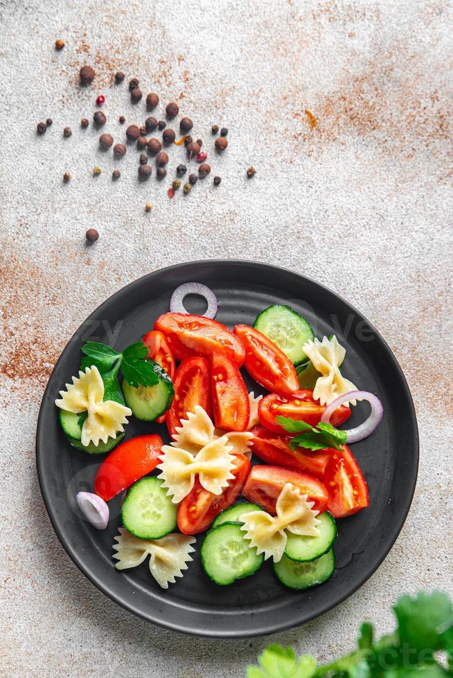salada de macarrão farfalle, tomate, pepino, cebola refeição saudável dieta foto