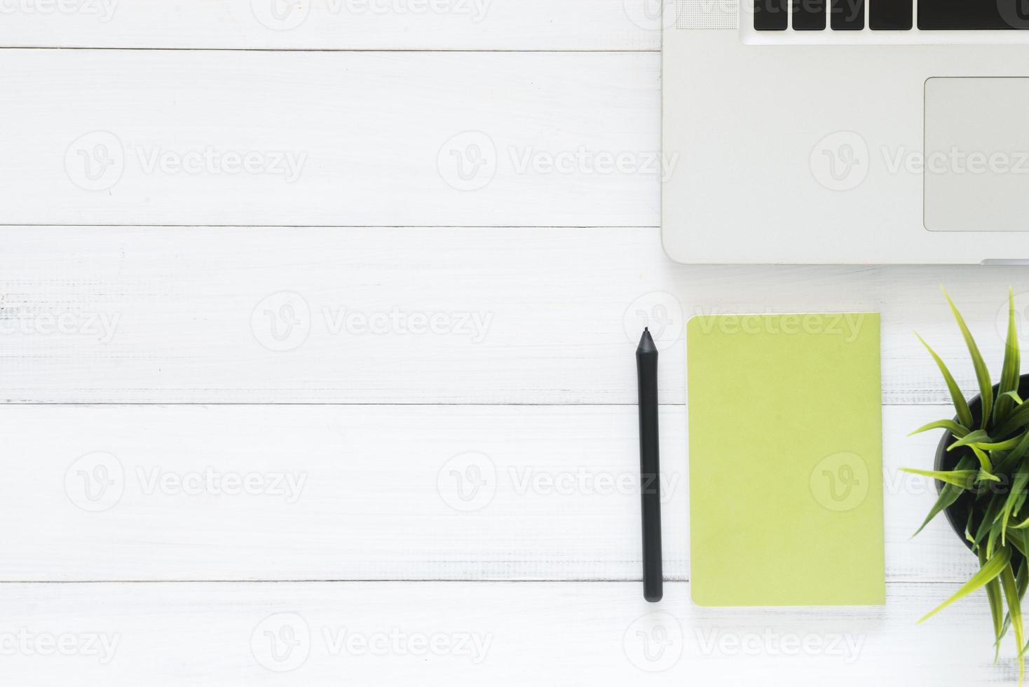 espaço de trabalho mínimo - foto criativa plana da mesa do espaço de trabalho. mesa de escritório de vista superior com laptop, mock up notebooks e planta em fundo branco de madeira. vista superior com cópia espaço, fotografia plana lay