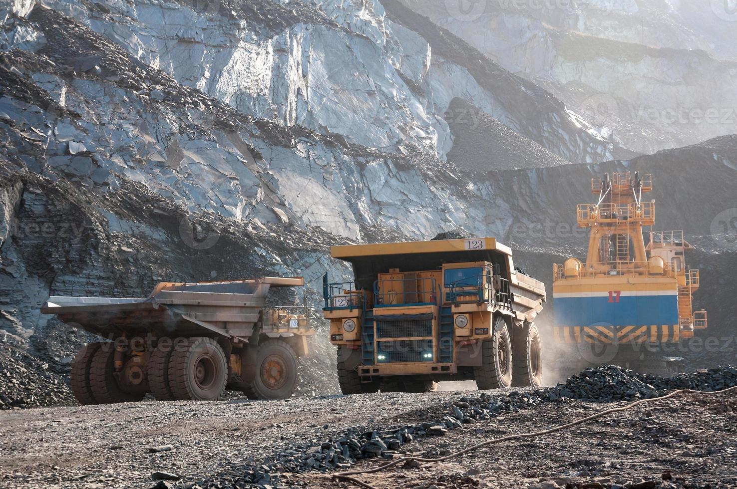 caminhões basculantes de mina a céu aberto conduzem sozinhos área industrial de pedreira de minério de ferro foto