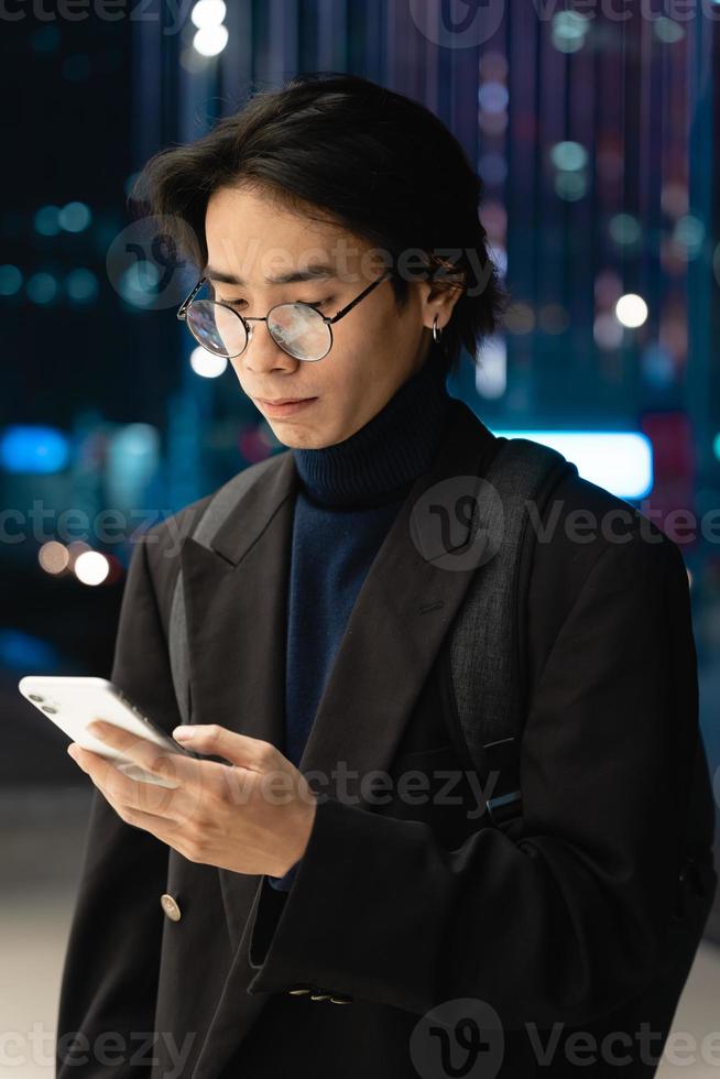 retrato de um empresário asiático usando uma máscara, na rua à noite foto