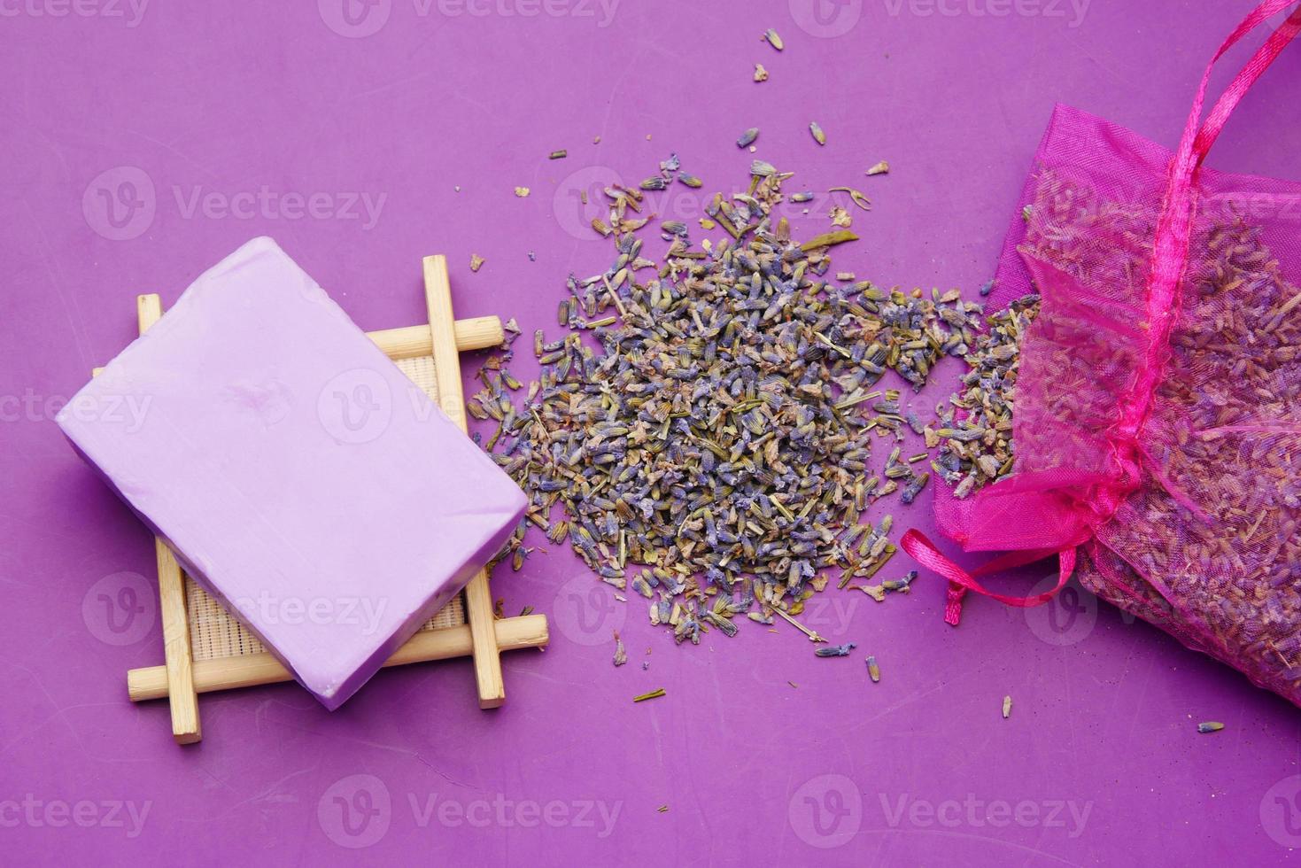 sabonete natural caseiro e flor de lavanda em fundo roxo foto