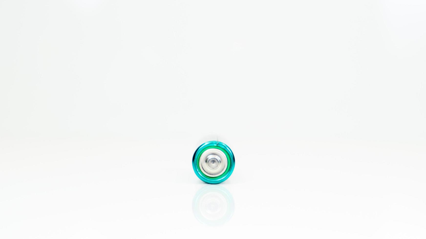 uma bateria alcalina em um fundo branco com reflexão. fornecimento de energia e conceito de reciclagem. copie o espaço. minimalismo. eliment aa é o tipo mais comum de baterias e acumuladores galvânicos. foto