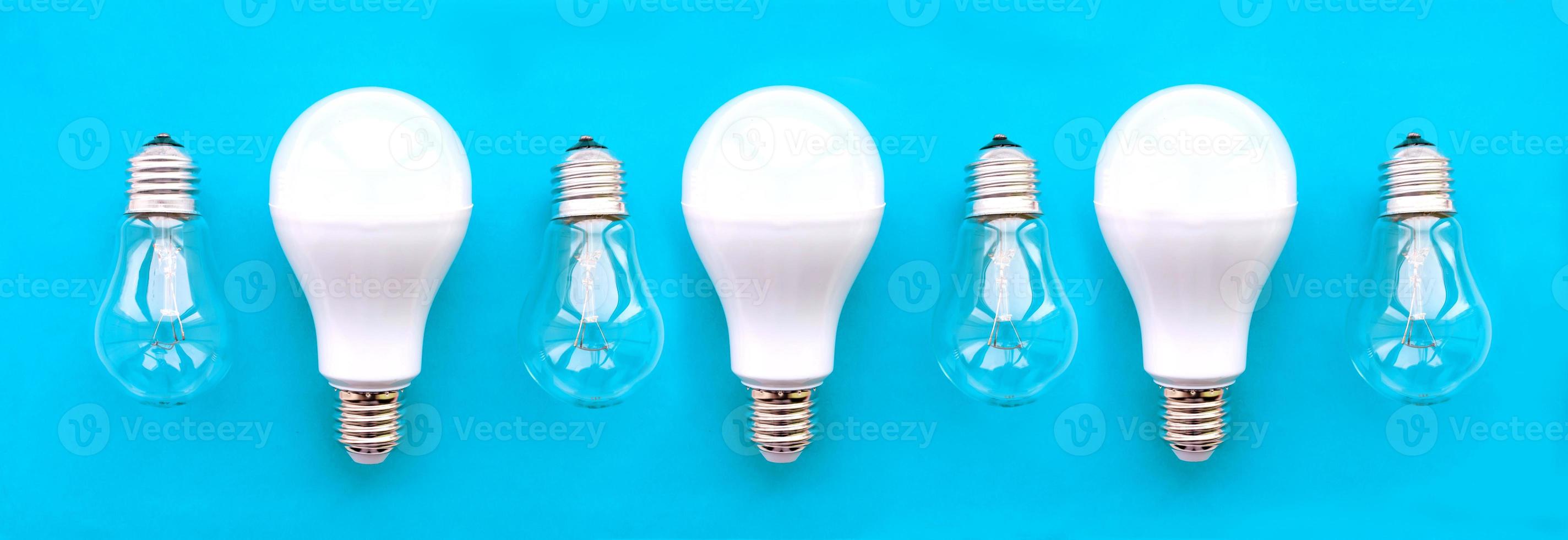 lâmpadas economizadoras de energia com lâmpadas incandescentes em uma fileira em um fundo azul. o conceito de economia de energia. foto
