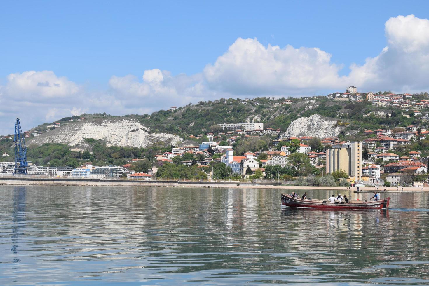 paisagem urbana das águas do mar negro na bulgária. pescadores indo para o mar no barco. belo destino de viagens e férias. água ondulada cristalina e céu azul suave. foto