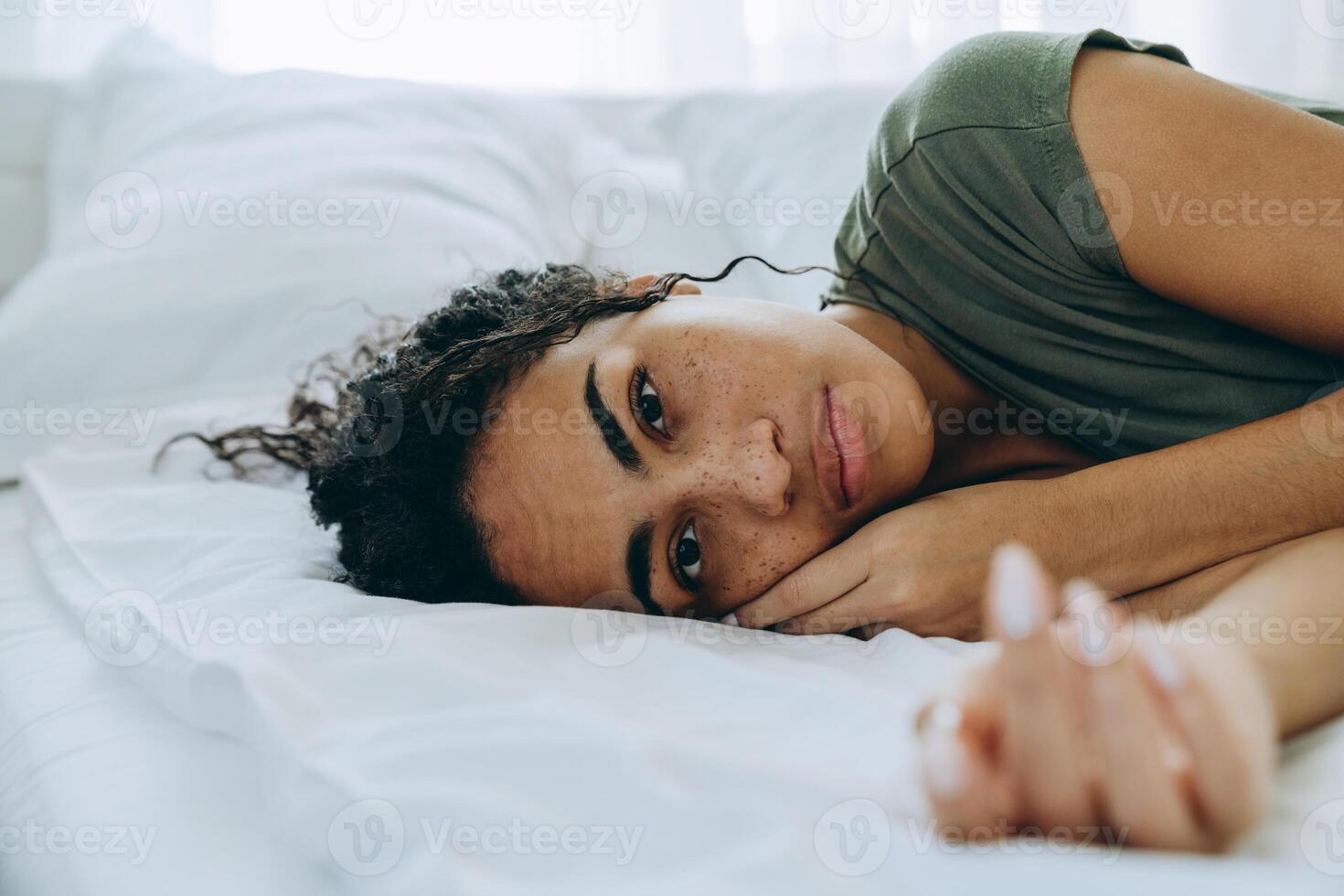 retrato de uma mulher triste africana deitada na cama foto