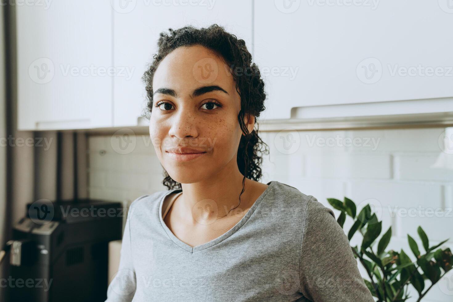 jovem negra sorrindo e olhando para a câmera na cozinha foto