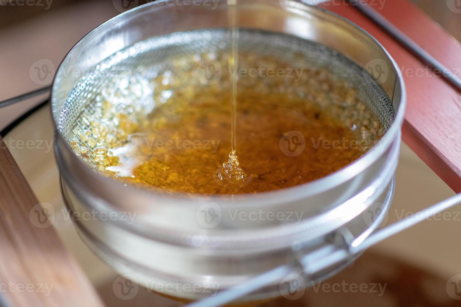 gota de mel de abelha pingando de favos hexagonais foto