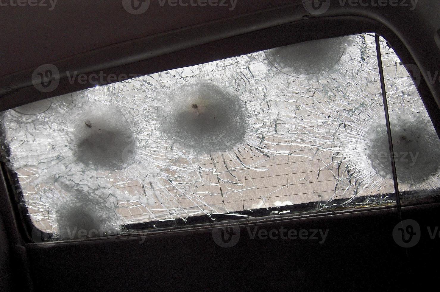 grande rachadura no pára-brisa do carro de um fragmento de bala de atirador militar foto
