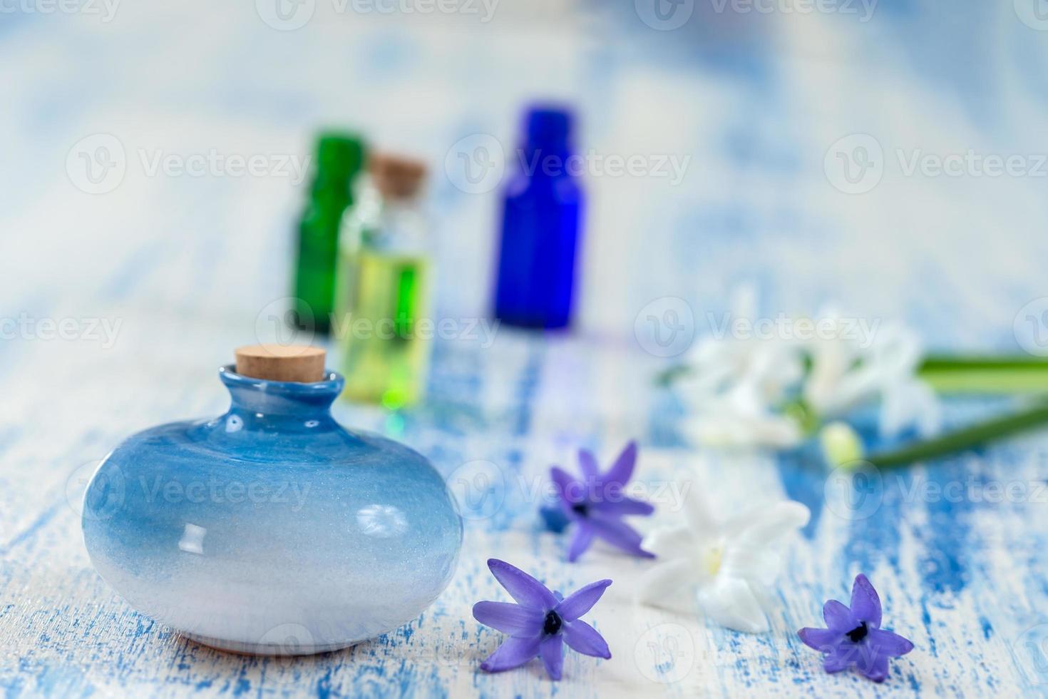 composição com óleo essencial e flor de jacinto em frasco de vidro e frasco de cerâmica em fundo de madeira velho foto