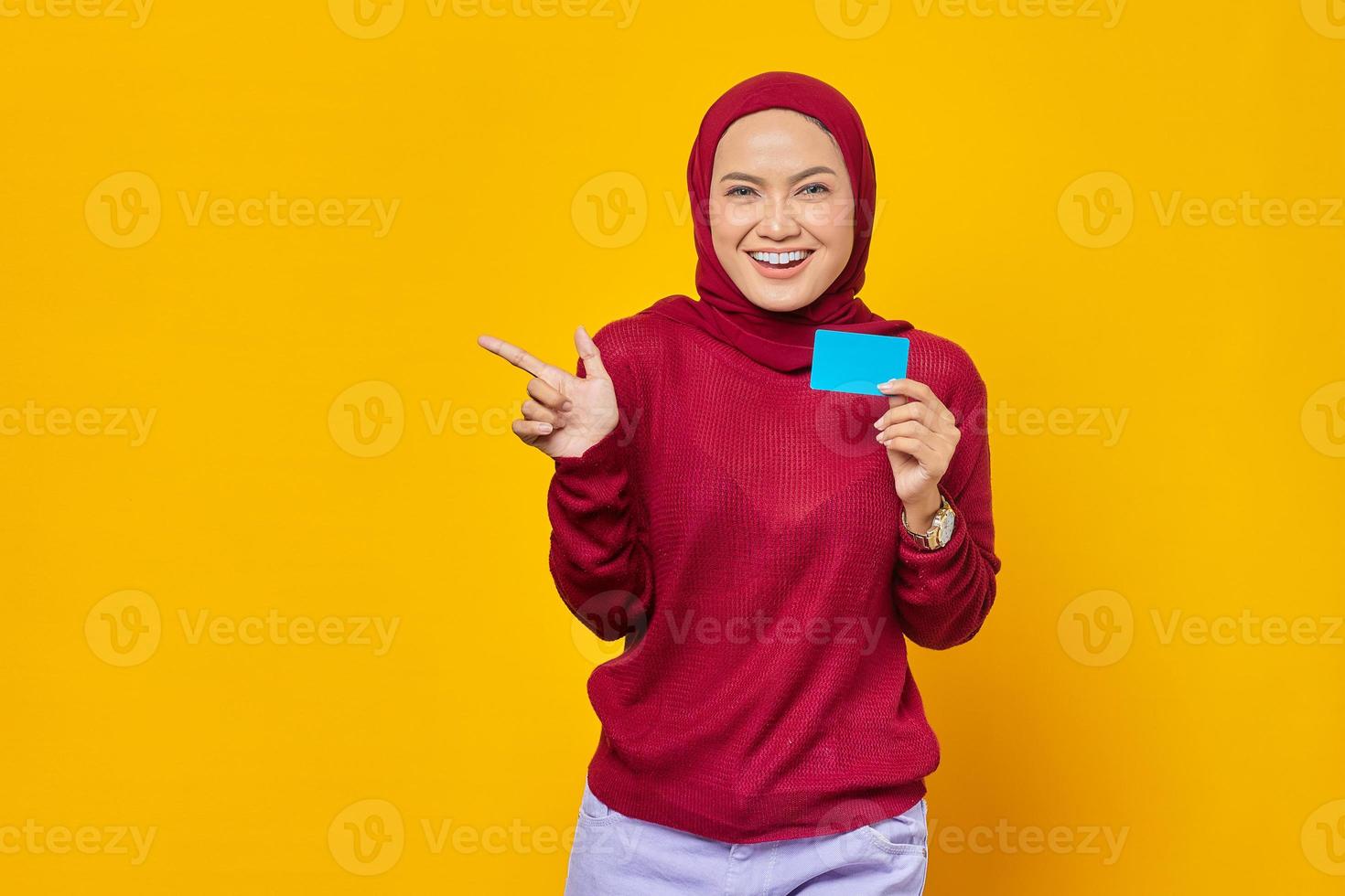 linda mulher asiática segurando um cartão de crédito foto