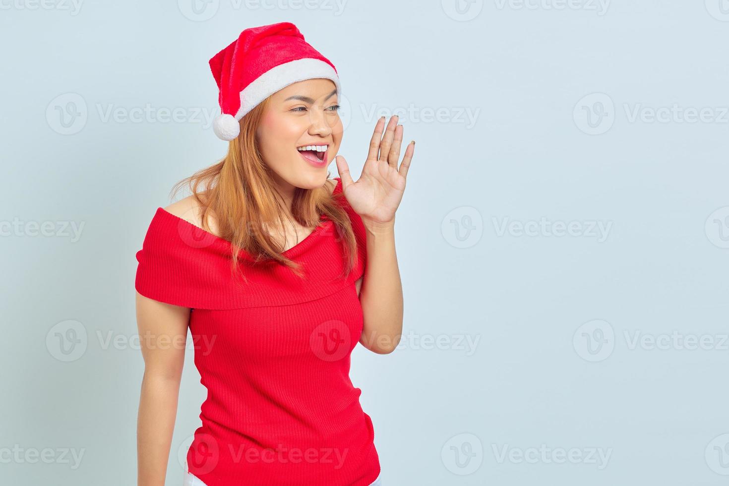 retrato de uma jovem mulher asiática com vestido de natal e gritando com expressão de surpresa foto