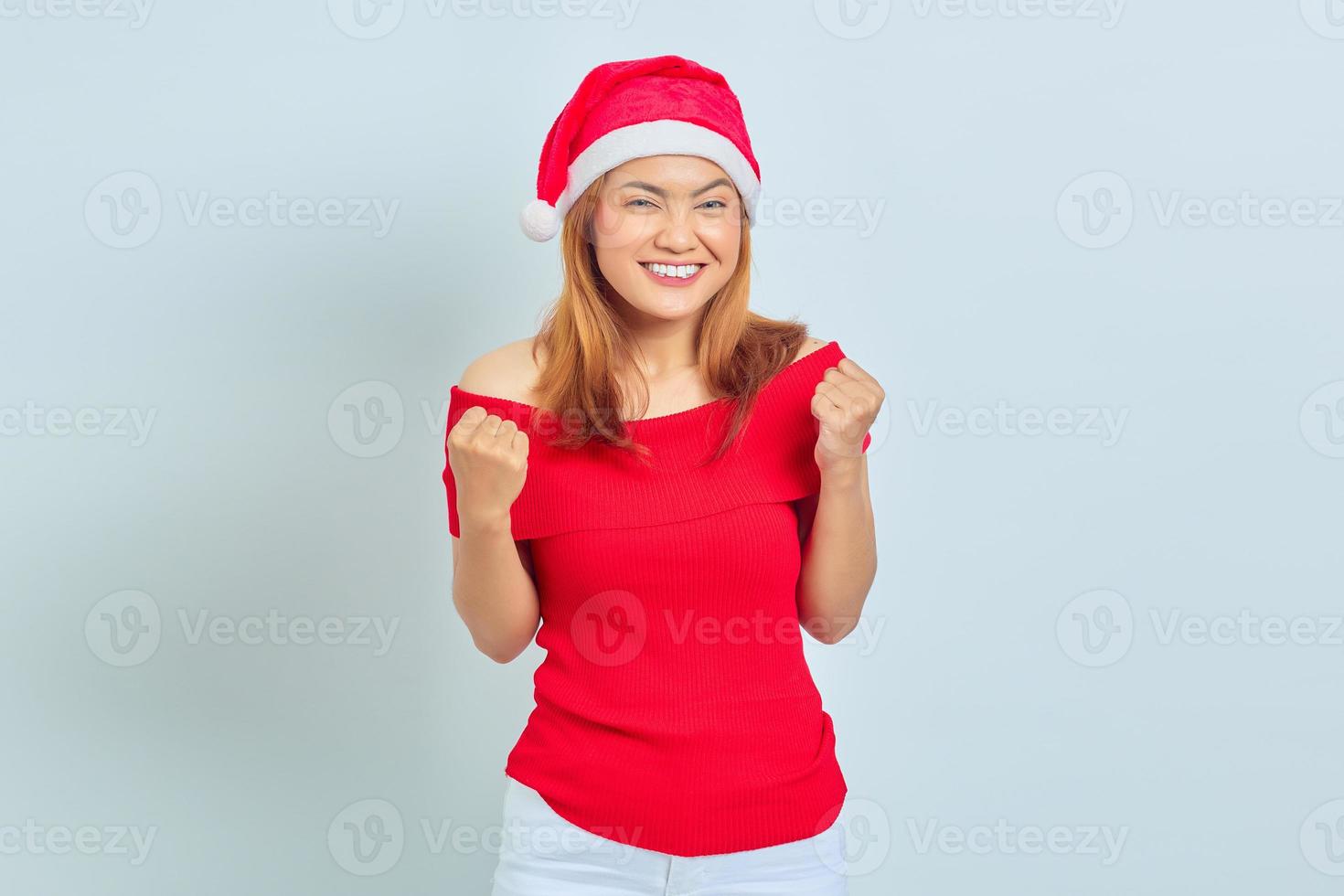 jovem asiática alegre com vestido de natal animada para celebrar o natal sobre fundo branco foto