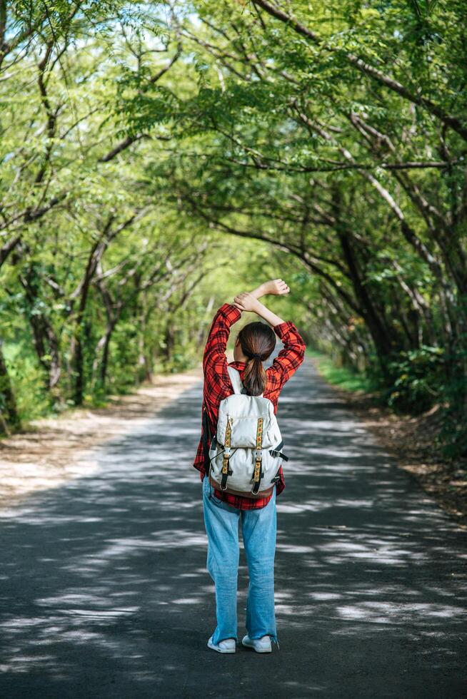 turistas femininas carregam uma mochila e ficam na rua. foto