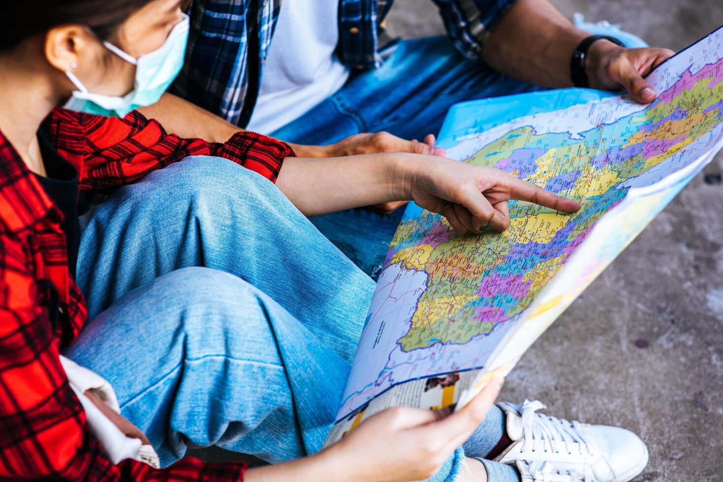 turistas masculinos e femininos olham para o mapa ao lado da ferrovia. foto