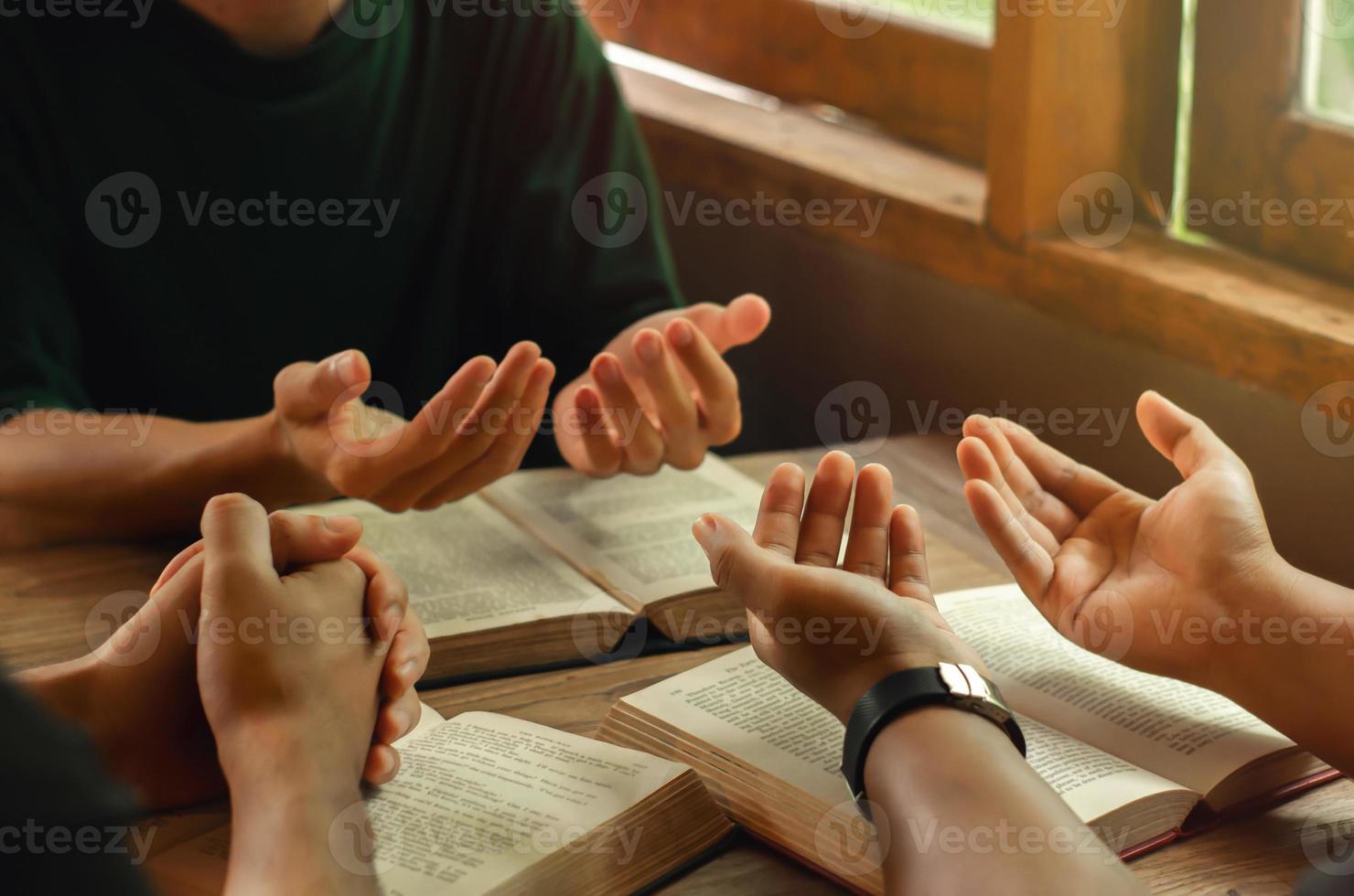 jovens cristãos se unem em oração e buscando as bênçãos de Deus. lendo a Bíblia e compartilhando o peitoril da janela do evangelho foto