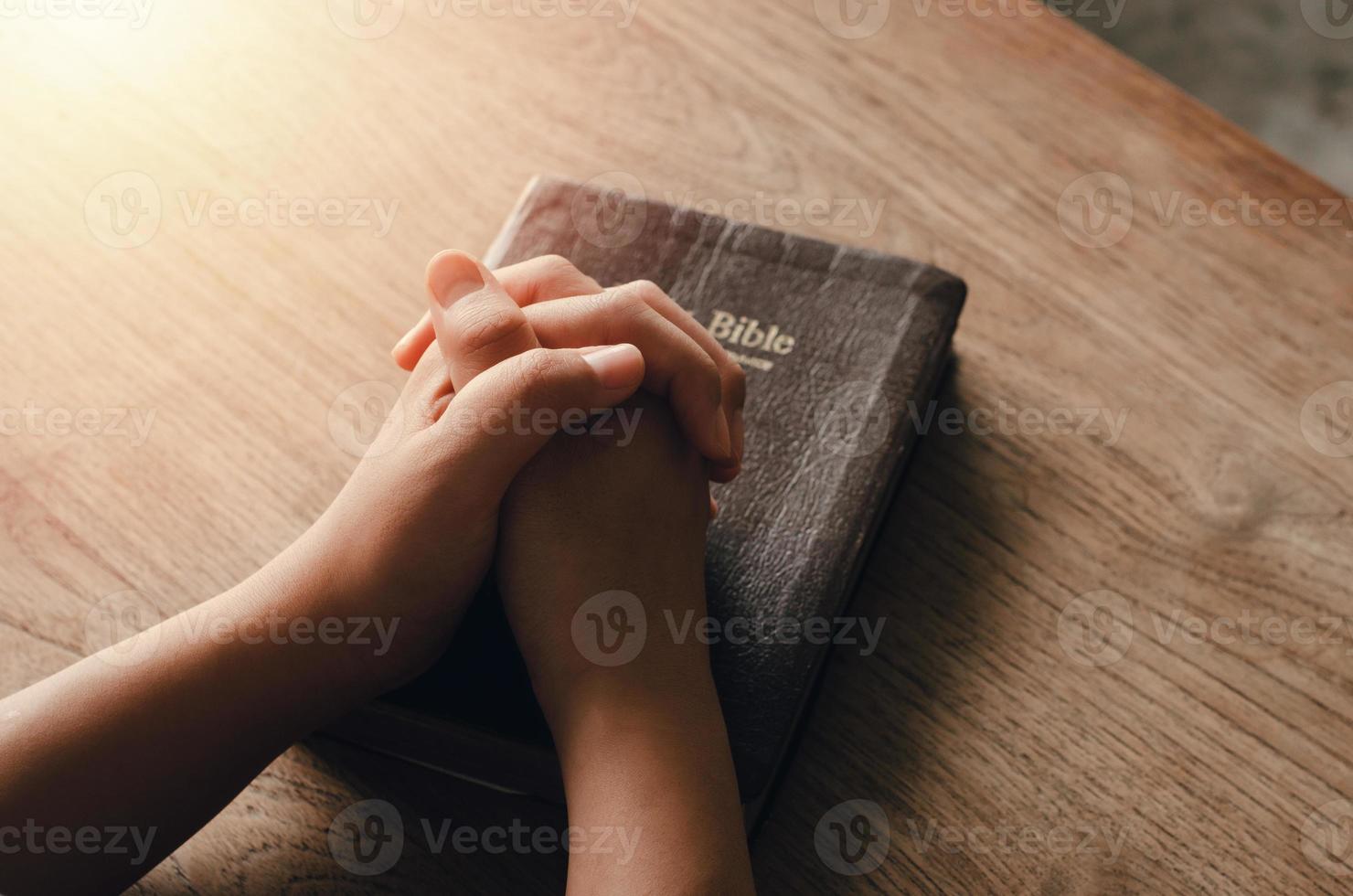 menina sentada e orando por bênçãos de Deus com a Bíblia de mãos postas em oração bíblica, espiritual e religiosa, comunique-se, fale com Deus. amor e perdão foto