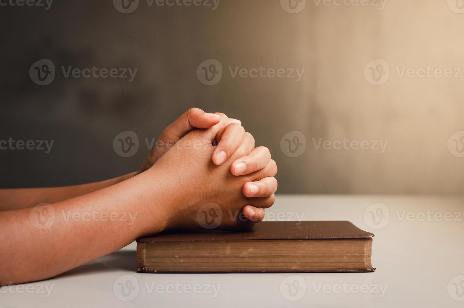 crise da vida cristã reze a deus homens rezem por uma bênção de deus por uma vida melhor. mão do homem orando a Deus com a Bíblia. acredite no bem um punhado de orações sobre uma mesa de madeira foto