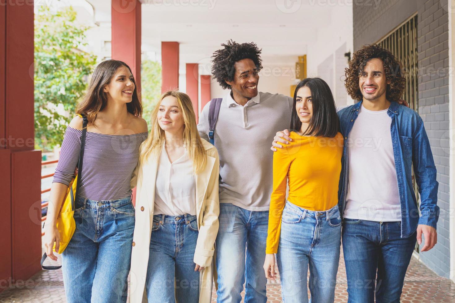 grupo multiétnico de estudantes caminhando juntos na rua. foto