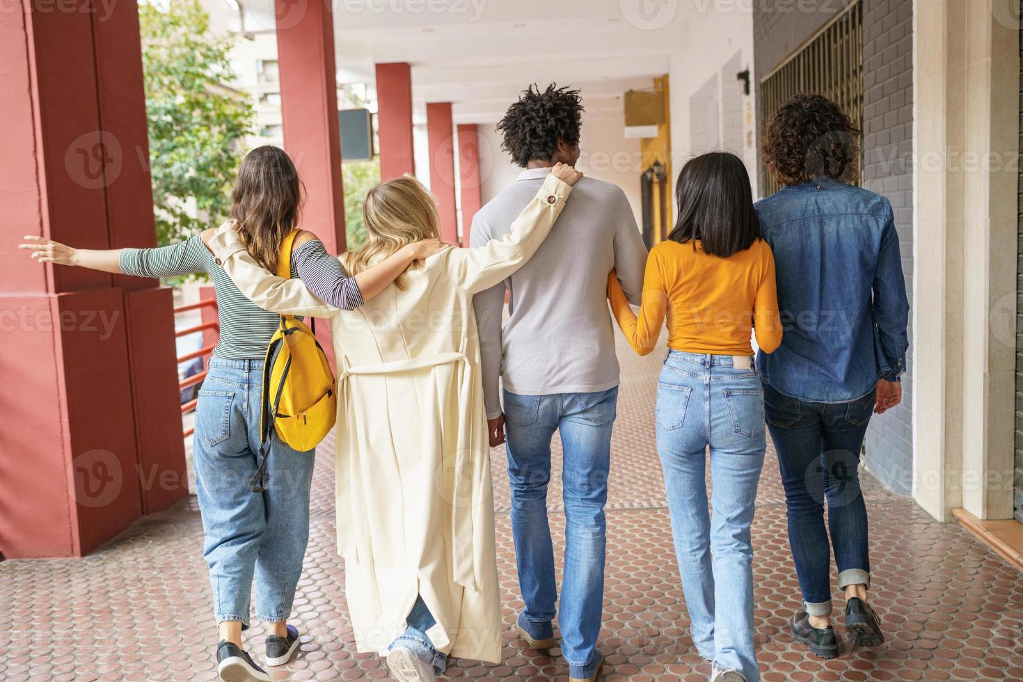 grupo multiétnico de amigos caminhando juntos na rua. foto