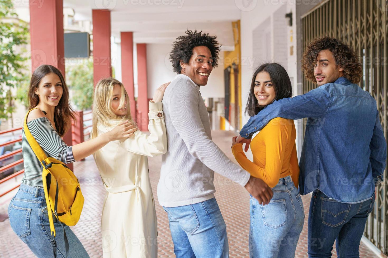 grupo multiétnico de amigos caminhando juntos na rua. foto