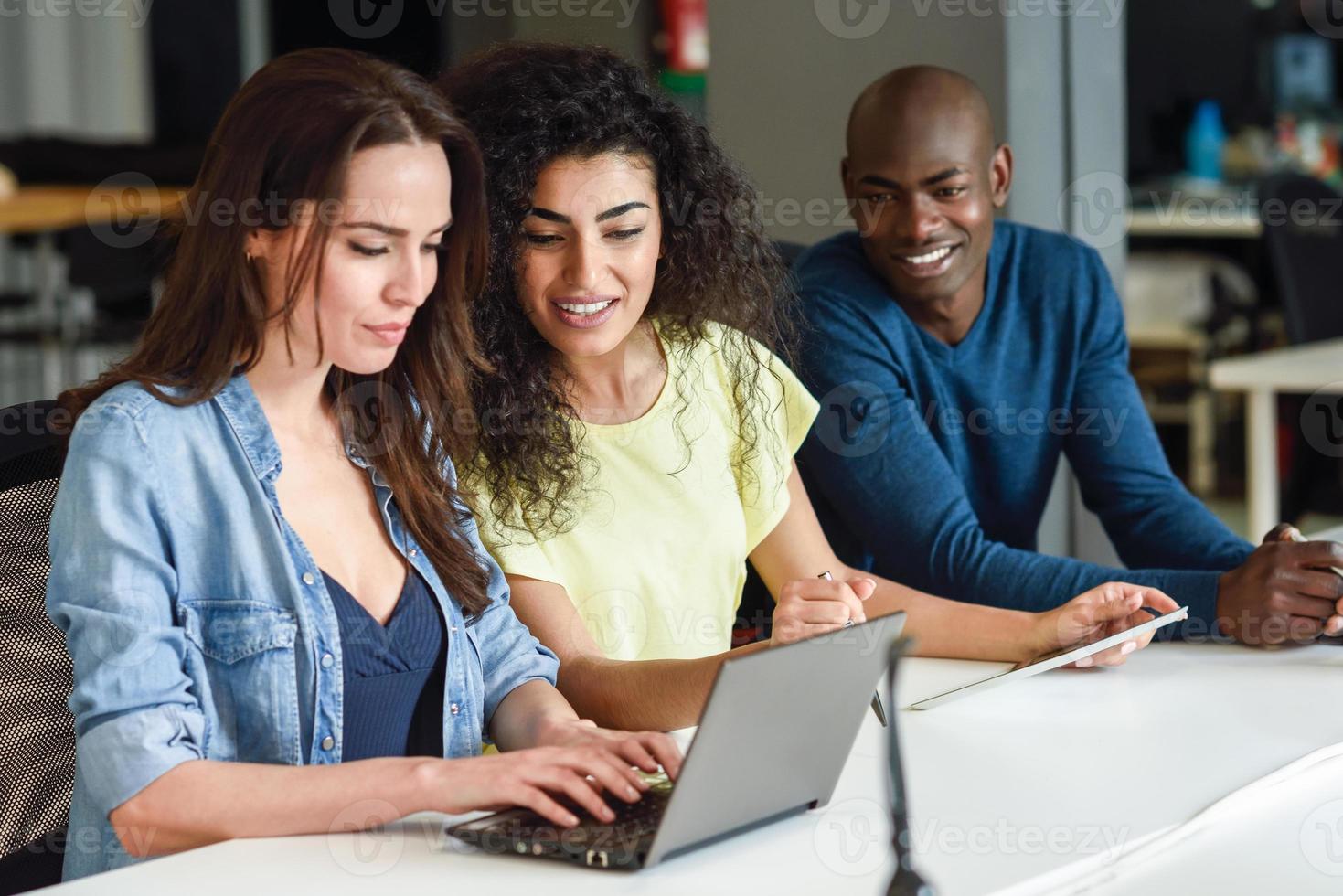 grupo multiétnico de jovens estudando com um laptop foto