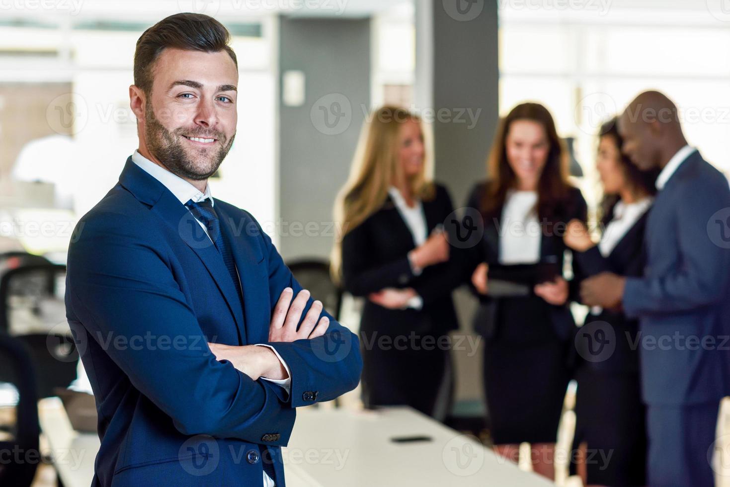 líder empresário em escritório moderno com empresários trabalhando em segundo plano foto