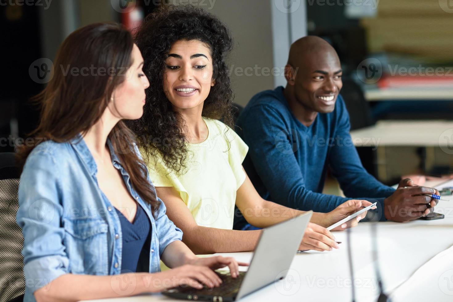 grupo multiétnico de jovens estudando com um laptop foto