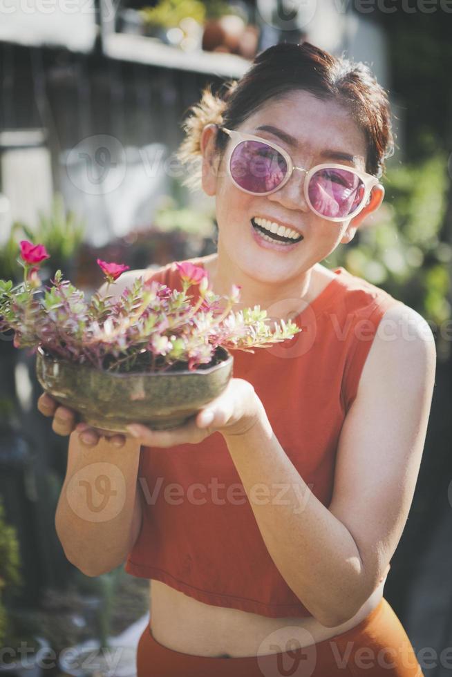 mulher feliz criando vaso de flor de portulaca foto