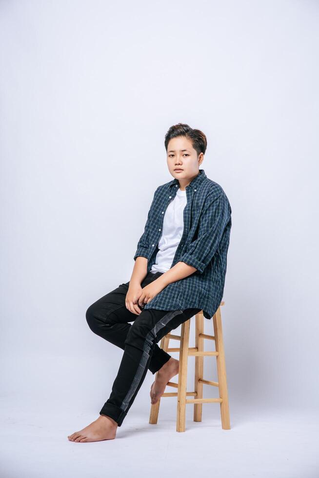 uma garota com uma camisa listrada, sentada em uma cadeira alta. foto