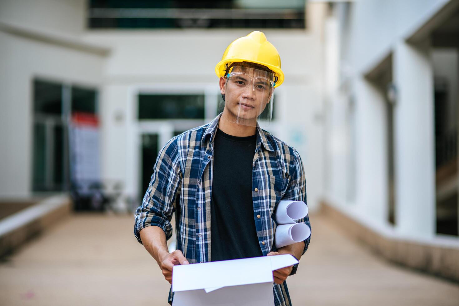 arquitetos seguram a planta do prédio e verificam a obra. foto