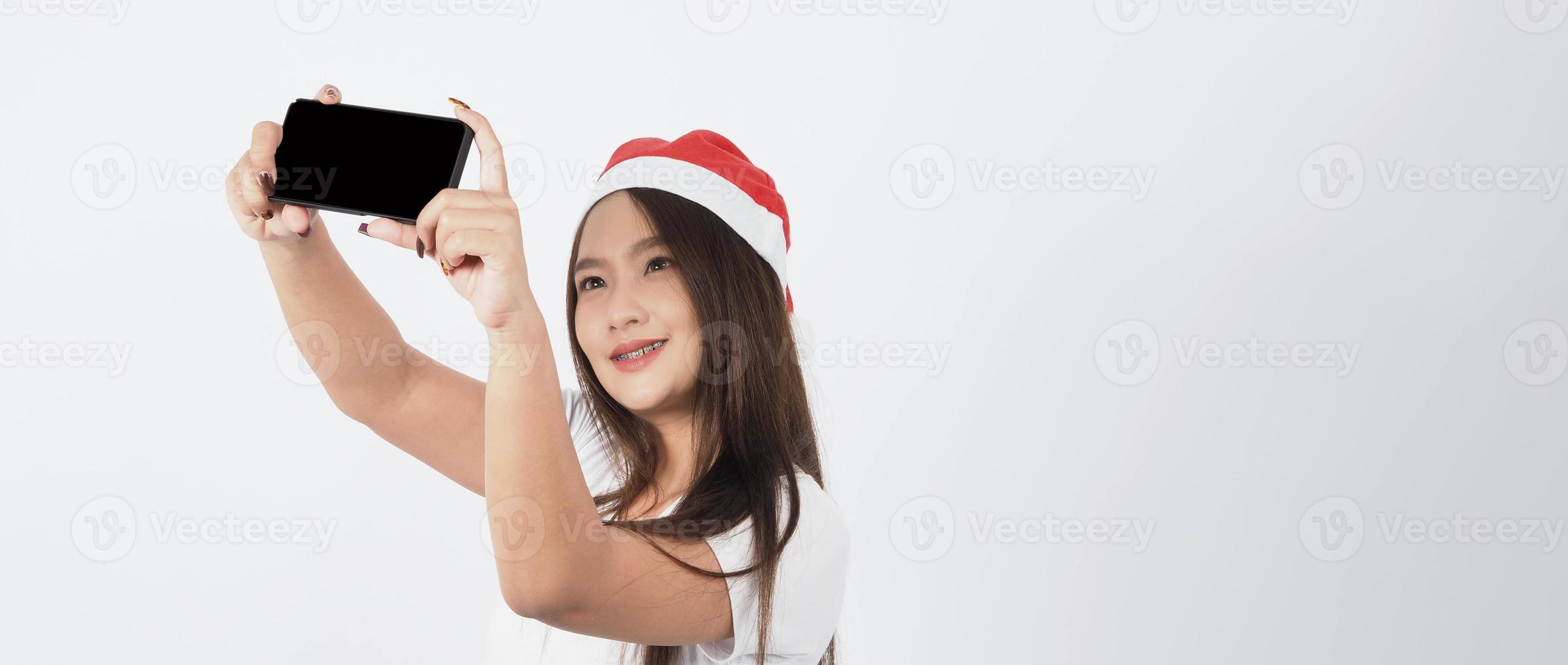 Mulher asiática com smartphone na mão que posa como selfie ou videochamada foto