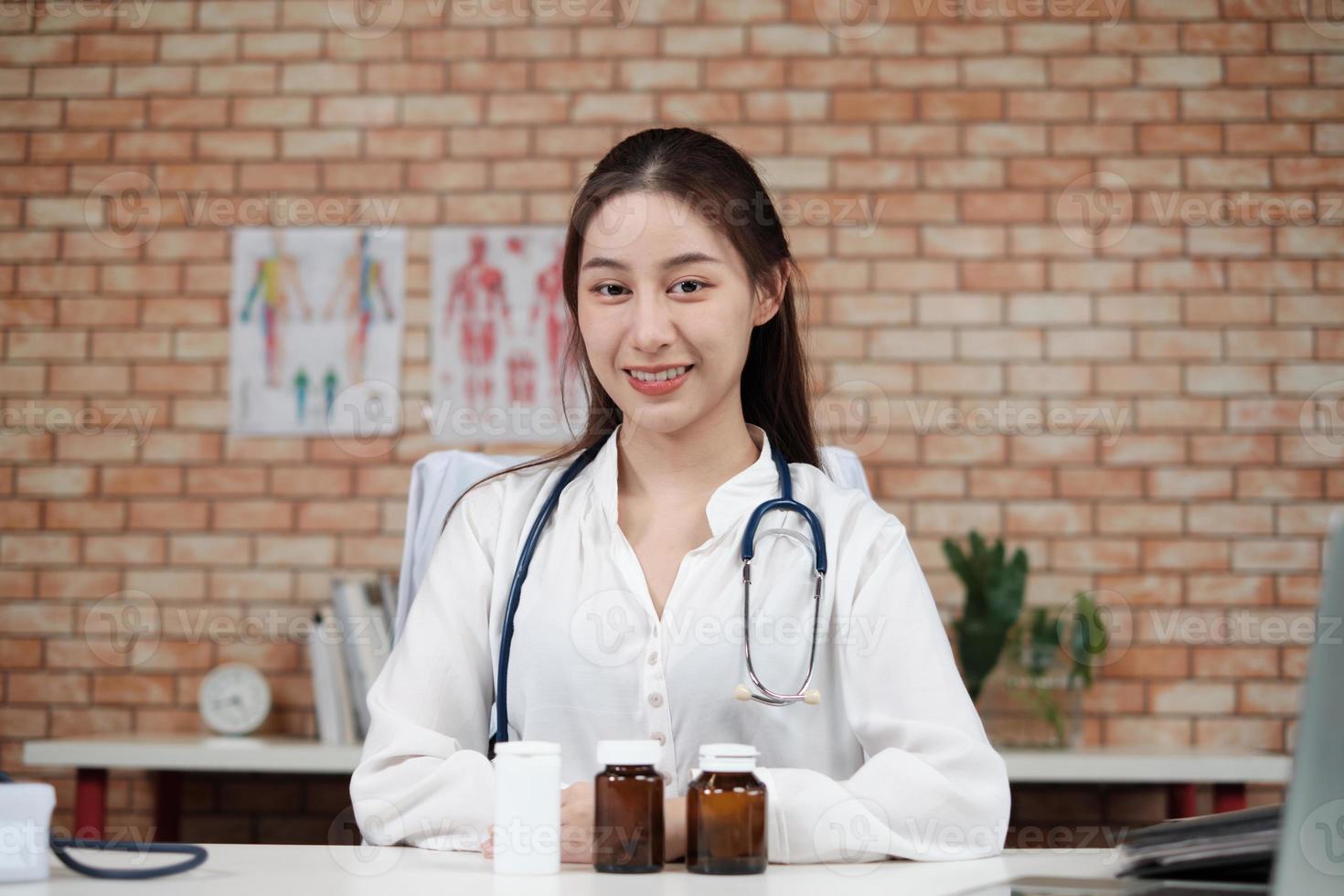 retrato da bela médica de etnia asiática em camisa branca com estetoscópio, sorrindo e olhando para a câmera na clínica do hospital. uma pessoa com experiência em tratamento profissional. foto