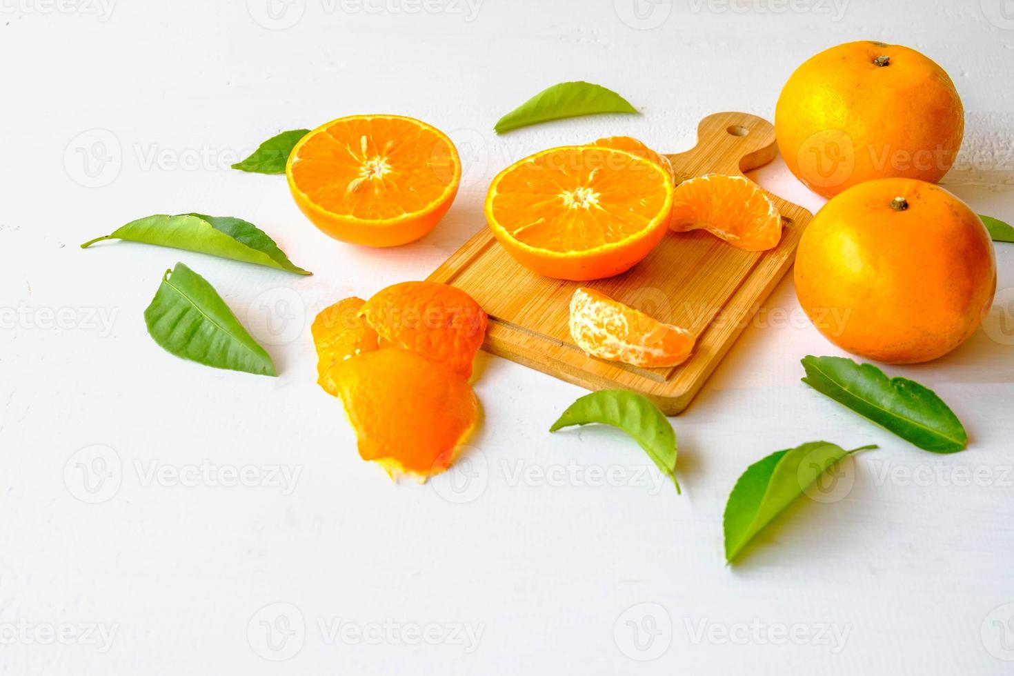frutas frescas de laranja cortadas ao meio em fundo branco de madeira foto