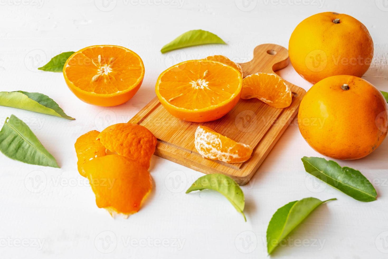 frutas frescas de laranja cortadas ao meio em fundo branco de madeira foto