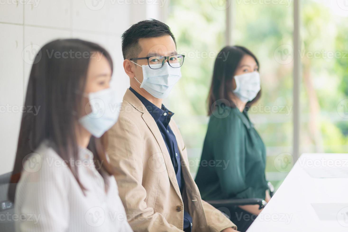 funcionários da empresa usando máscara durante o trabalho no escritório para manter a higiene seguem a política da empresa. preventivos durante o período de epidemia de coronavírus ou covid19. foto