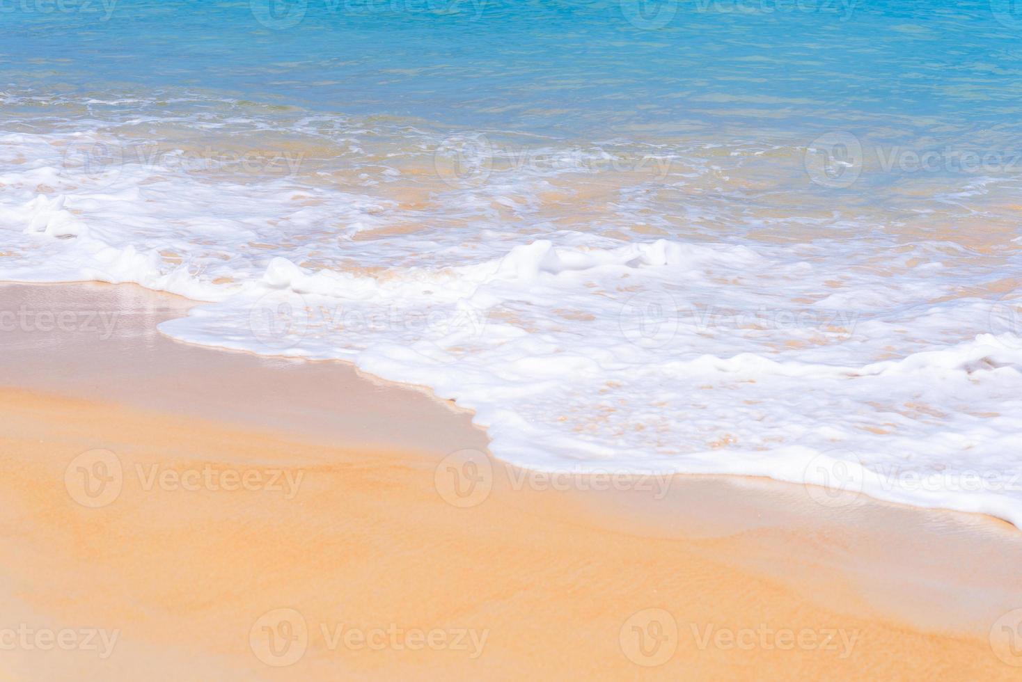 fechar a bela onda do mar na praia de areia tropical no fundo do verão foto