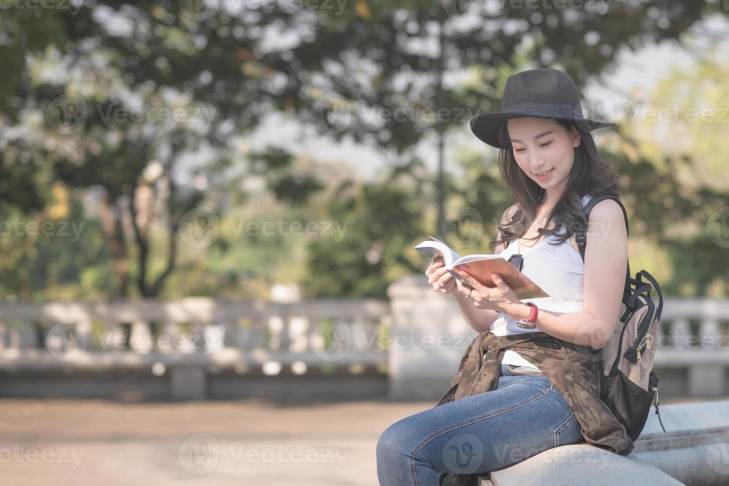 mulher linda turista solo asiático lendo o guia de viagens à procura do local de turismo de turistas. viagens de férias no verão. foto