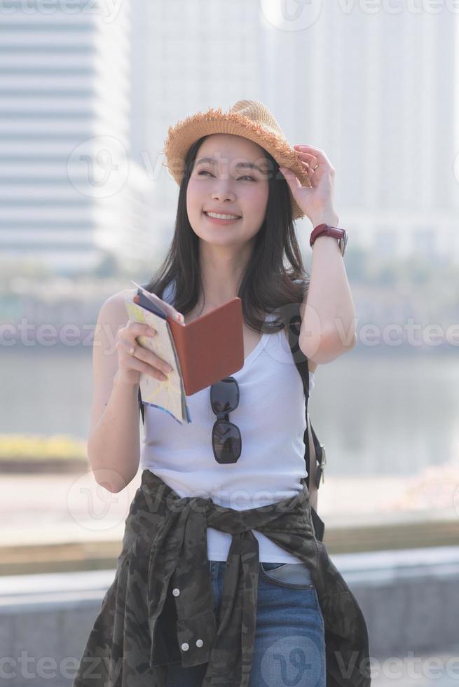 mulher linda turista solo asiático sorrindo e procurando o local de turismo de turistas. viagens de férias no verão. foto