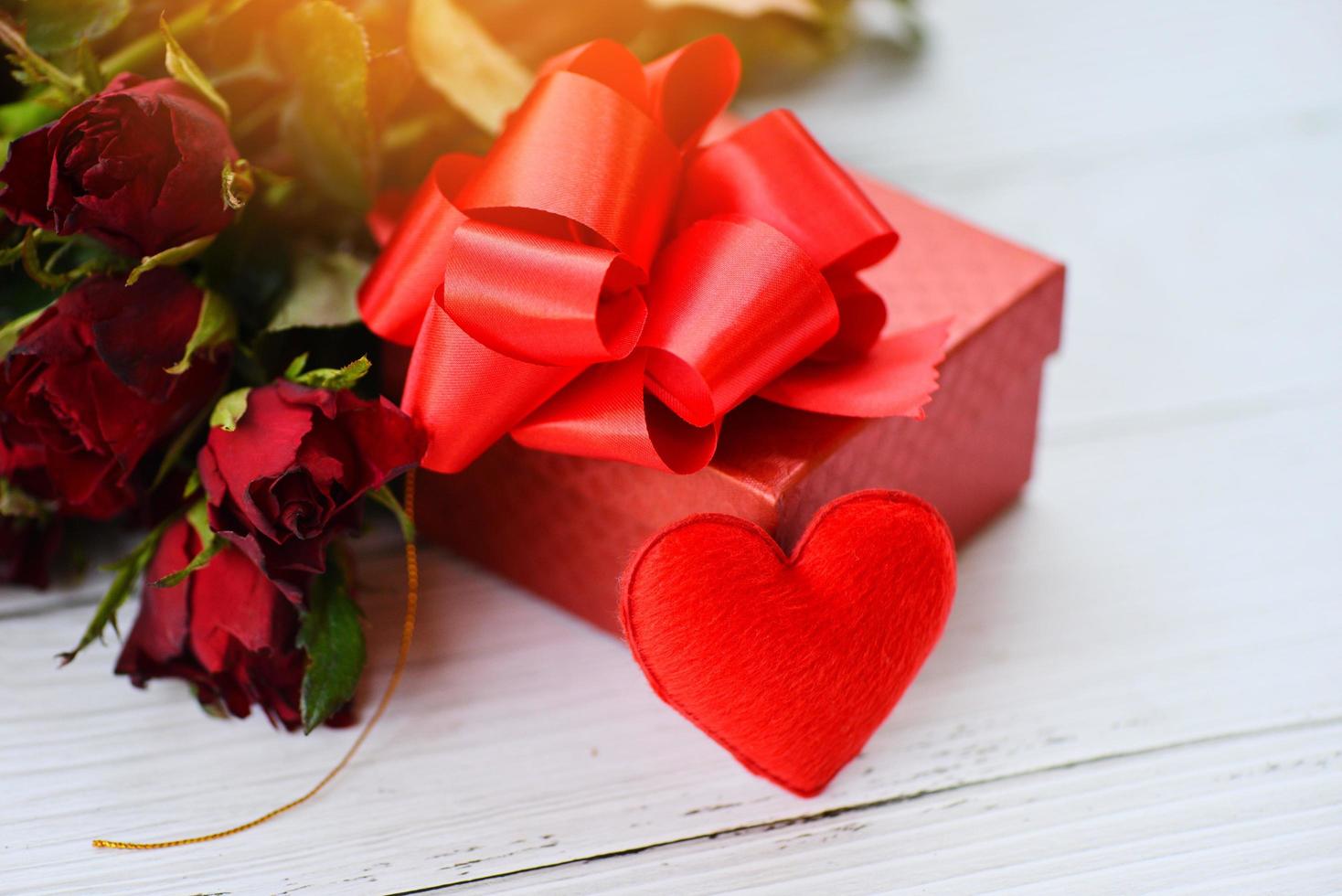 caixa de presente decorada com flores de rosas e fundo de amor do coração dia dos namorados foto