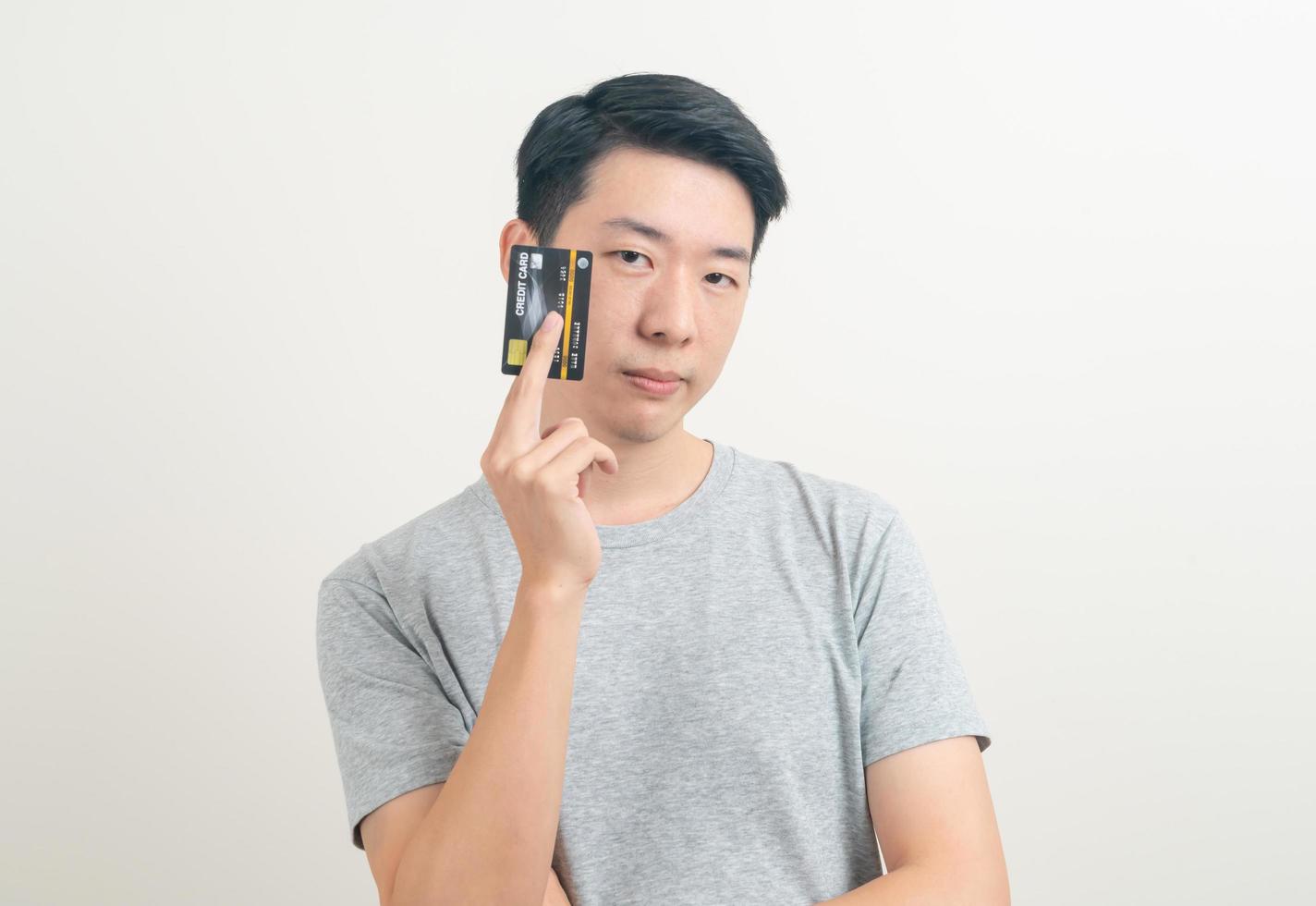 jovem asiático segurando um cartão de crédito foto