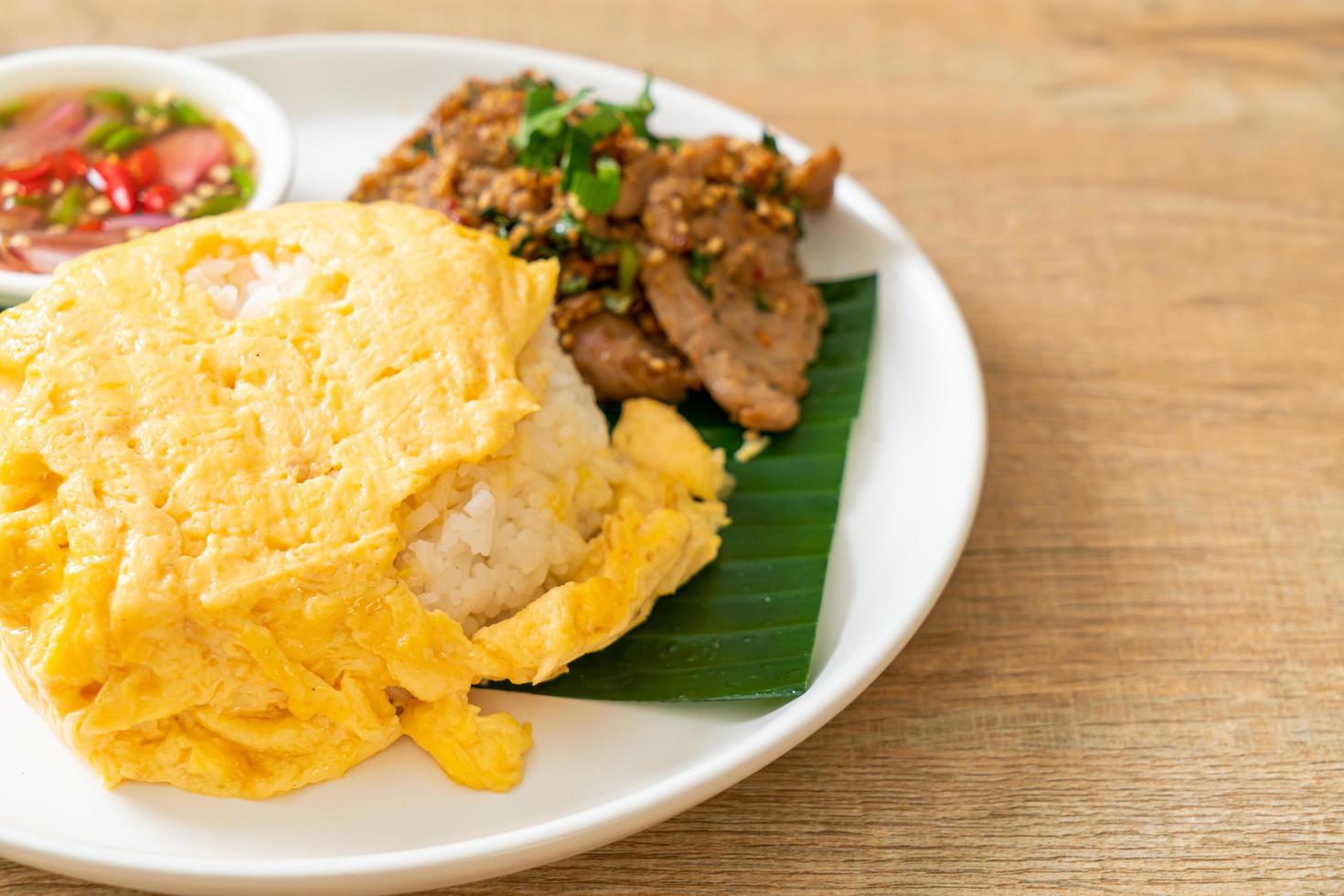 ovo com arroz coberto com carne de porco grelhada e molho picante foto