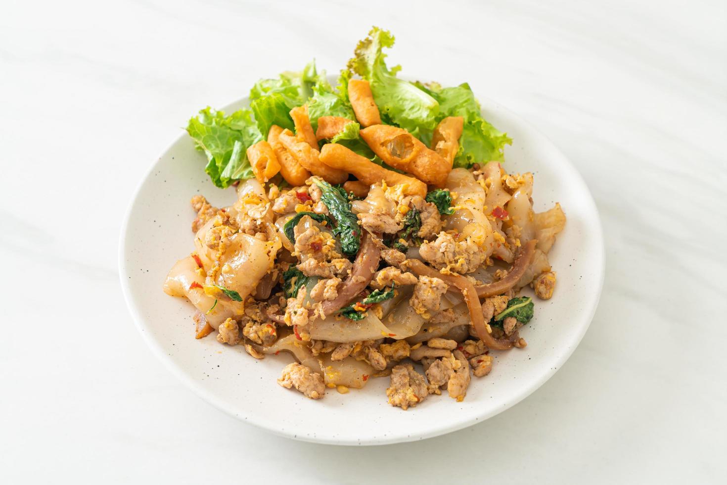 macarrão frito com frango picado e manjericão foto