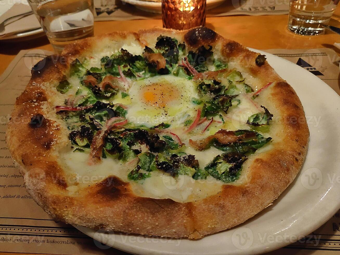 pizza cornet preto calabresa saborosa coberta de cozinhar com presunto e especiarias na chapa branca. foto