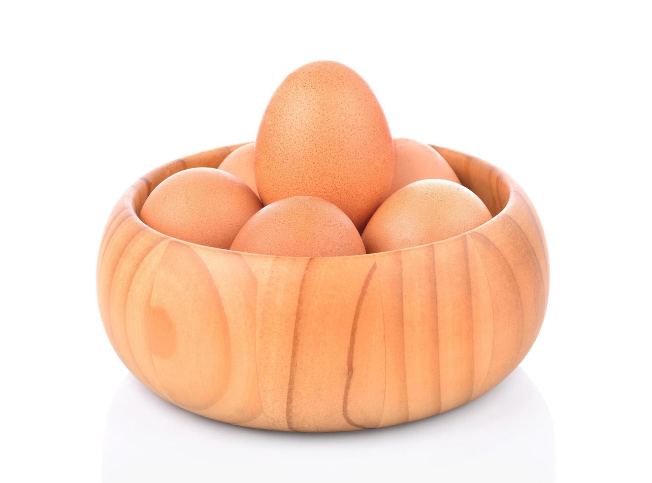 ovo em uma tigela de madeira isolado no fundo branco foto