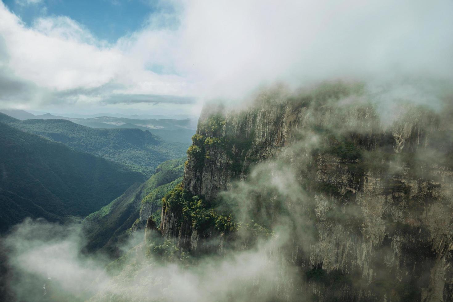 cânion de Fortaleza com penhascos rochosos íngremes cobertos por floresta densa e neblina subindo a ravina perto de Cambará do Sul. uma pequena cidade do sul do brasil com incríveis atrativos turísticos naturais. foto