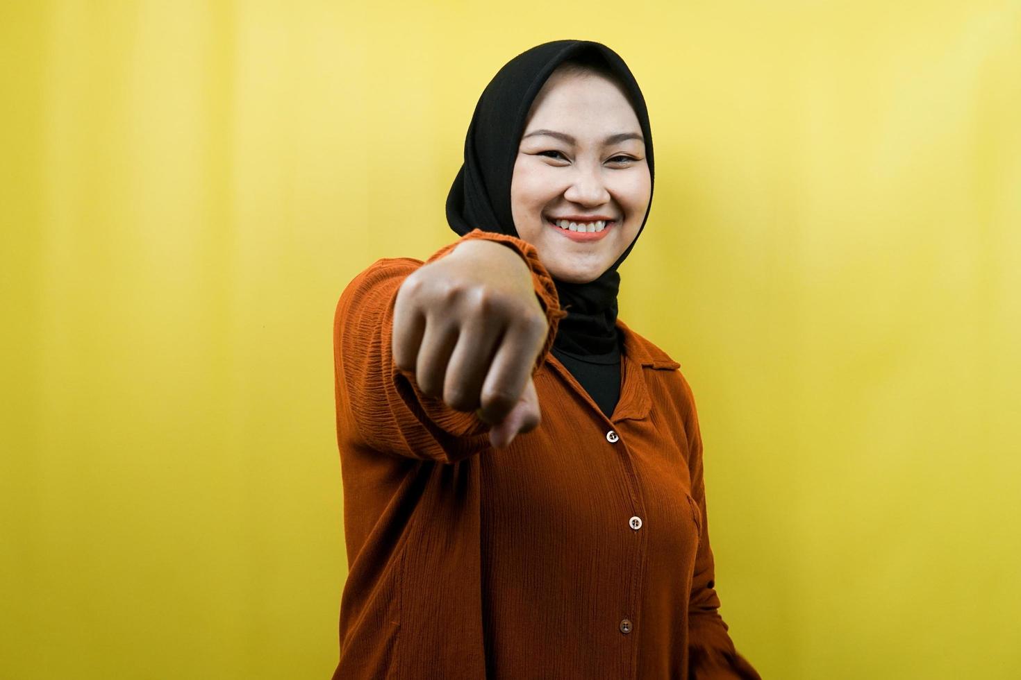 bela jovem muçulmana asiática com os punhos cerrados para a câmera, socos, luta, cooperação, olhos brilhando, olhando para a câmera isolada foto